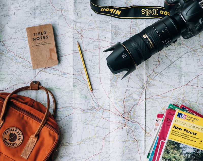 Flatlay of map, camera, and backpack